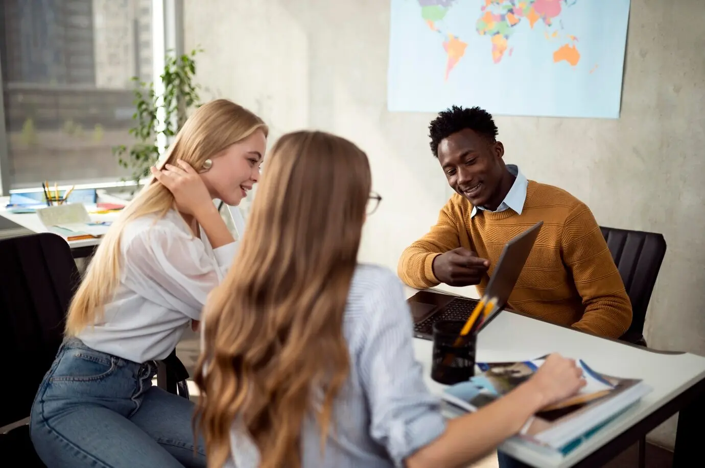 Halbnahe Aufnahme von Menschen, die auf einen Laptop schauen.